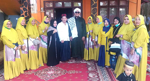 Berfoto bersama anggota DPRD Kutim Kidang (tengah dua ) kenakan baju muslim warna putih bersama istri Mursidah berbaju muslimah hitam bersama penceramah Habib Muhammad Hamzah dan majelis taklim binaanya usai menggelar peringatan Isra Miraj di kediaman pribadinya Bengalon, Kutim
